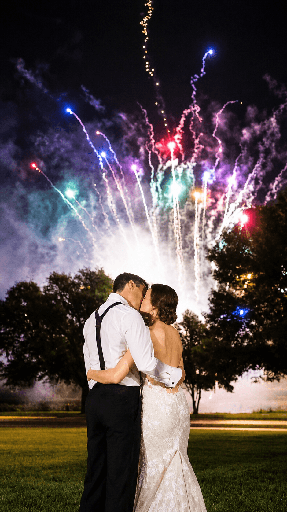 Wedding couple embracing beneath fireworks