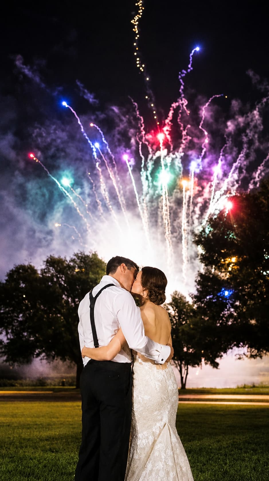 Wedding couple embracing beneath fireworks